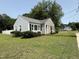 Inviting home with manicured lawn, gray siding, black shutters, and decorative landscaping at 306 W Canary St, Dunn, NC 28334