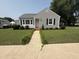 Charming one-story home features a landscaped front yard, sidewalk, and gray siding at 306 W Canary St, Dunn, NC 28334