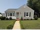 Charming single-story home featuring gray siding, black shutters, and a well-manicured front yard with a stone walkway at 306 W Canary St, Dunn, NC 28334