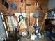 A storage area or shed filled with gardening tools such as rakes, shovels, and brooms at 306 W Canary St, Dunn, NC 28334