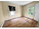Bedroom featuring hardwood floors, natural light from two windows, and neutral-toned walls at 312 W Front St, Oxford, NC 27565