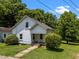 Quaint two-story home with an inviting front yard and well-established greenery creating a serene setting at 312 W Front St, Oxford, NC 27565