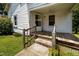 Inviting front porch with wooden deck, natural light, and steps leading to a well-maintained yard at 312 W Front St, Oxford, NC 27565