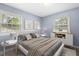Light-filled bedroom featuring blue walls, hardwood floors, and modern furnishings at 4021 Chaucer Dr, Durham, NC 27705
