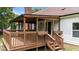 A covered brown wooden back deck offers outdoor living and complements the white house with a brick chimney at 4259 Old Faison Rd, Knightdale, NC 27545