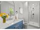 Updated bathroom with a blue vanity, marble countertop, and a glass-enclosed shower at 4259 Old Faison Rd, Knightdale, NC 27545