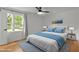 Bright bedroom featuring wood floors, a ceiling fan, and a comfortable bed with blue accents at 4259 Old Faison Rd, Knightdale, NC 27545