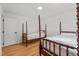 Cozy bedroom featuring hardwood floors and twin four-poster beds with classic white linens at 4259 Old Faison Rd, Knightdale, NC 27545