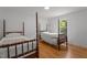 Cozy bedroom featuring hardwood floors and twin four-poster beds with classic white linens at 4259 Old Faison Rd, Knightdale, NC 27545