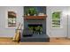 Close up of the living rooms fire place with a mantle, books and plants at 4259 Old Faison Rd, Knightdale, NC 27545