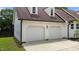 Spacious two-car garage with white doors, brown roof and side door at 4259 Old Faison Rd, Knightdale, NC 27545
