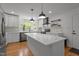 Modern kitchen featuring white cabinets, stainless appliances, large island, and stylish pendant lighting at 4259 Old Faison Rd, Knightdale, NC 27545