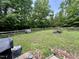 Expansive backyard features lush greenery, a wooden fence, and a cozy fire pit at 4601 Orange Grove Rd, Hillsborough, NC 27278