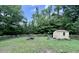Tranquil backyard featuring a wooden shed, fire pit and a rustic wooden fence at 4601 Orange Grove Rd, Hillsborough, NC 27278