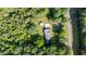 Aerial view of a home with a carport surrounded by trees and a nearby road at 4964 Stafford Mill Rd, Liberty, NC 27298