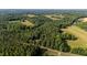 Aerial view of property surrounded by trees, fields, and long private road at 4964 Stafford Mill Rd, Liberty, NC 27298