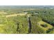 Panoramic aerial view of the property with surrounding trees and its proximity to a paved road at 4964 Stafford Mill Rd, Liberty, NC 27298