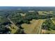 Expansive aerial view of the property with lush green fields and dense surrounding forests at 4964 Stafford Mill Rd, Liberty, NC 27298
