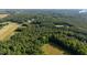 Captivating aerial view displaying the property's lush, tree-lined landscape and serene surroundings at 4964 Stafford Mill Rd, Liberty, NC 27298