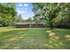 Lush backyard with mature trees surrounding the brick home at 4964 Stafford Mill Rd, Liberty, NC 27298