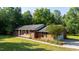 Traditional brick home with well-maintained landscaping, covered front porch, and attached garage at 4964 Stafford Mill Rd, Liberty, NC 27298