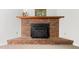 Close-up of the brick fireplace with a wooden mantel, providing a cozy focal point in the living room at 4964 Stafford Mill Rd, Liberty, NC 27298