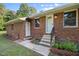 Charming brick home featuring a well-lit front entry with manicured landscaping at 4964 Stafford Mill Rd, Liberty, NC 27298