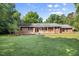 Charming single story brick home with manicured front lawn and a welcoming, covered front porch at 4964 Stafford Mill Rd, Liberty, NC 27298