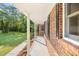 View of the covered front porch with brick columns, offering a shady place to relax at 4964 Stafford Mill Rd, Liberty, NC 27298