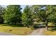 View of a home with beautiful mature trees on a lush green lawn at 4964 Stafford Mill Rd, Liberty, NC 27298