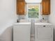 Bright laundry room features a washer, dryer, and plenty of storage with wooden cabinets above appliances at 4964 Stafford Mill Rd, Liberty, NC 27298
