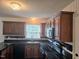 A view of the kitchen featuring dark cabinets, tile countertops, and stainless steel appliances at 5301 Peacenest Dr, Raleigh, NC 27610