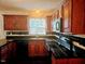 Modern kitchen features dark countertops, wood cabinets, and sleek appliances at 5301 Peacenest Dr, Raleigh, NC 27610