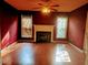 Living room with a fireplace, wood floors, two windows, and a modern ceiling fan at 5301 Peacenest Dr, Raleigh, NC 27610