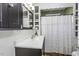 Bright bathroom features a classic white sink, dark wood cabinetry, and a charming decorative shower curtain at 931 Eastern Ave, Nashville, NC 27856