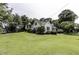 Expansive front yard showcases a well-manicured lawn, mature trees, and a charming two-story home with green shutters at 931 Eastern Ave, Nashville, NC 27856