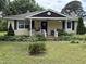 Charming yellow house featuring a welcoming front porch and meticulously landscaped front yard at 9439 Clayton Blvd, Clayton, NC 27520