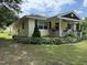 Charming yellow home with a welcoming front porch and well-maintained landscaping at 9439 Clayton Blvd, Clayton, NC 27520