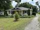 Quaint yellow home featuring a charming front porch, landscaped yard, and inviting curb appeal at 9439 Clayton Blvd, Clayton, NC 27520