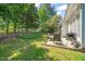 Spacious backyard with mature trees, featuring an outdoor seating area and grill at 1 Lake Hill Dr, Durham, NC 27713