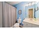 Bathroom with blue walls, a shower with curtain, and a white vanity at 1 Lake Hill Dr, Durham, NC 27713