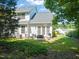 Rear exterior view of a white two-story home with a patio and landscaped backyard at 1 Lake Hill Dr, Durham, NC 27713