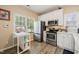 Bright kitchen features stainless steel appliances, white cabinets, and wood-look floors, with ample natural light at 1 Lake Hill Dr, Durham, NC 27713