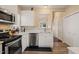 Galley kitchen features stainless steel appliances, white cabinets, and a pass-through window to the living area at 1 Lake Hill Dr, Durham, NC 27713
