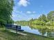 Relax on the bench overlooking the serene lake, surrounded by lush greenery and a calming atmosphere at 1 Lake Hill Dr, Durham, NC 27713