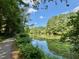 Scenic view of the community lake with a paved trail lined with trees, offering a serene and natural setting at 1 Lake Hill Dr, Durham, NC 27713