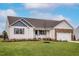 Inviting home with a well-maintained lawn, stone accents, and a covered porch for relaxing outdoors at 10725 Farmall Dr, Middlesex, NC 27557