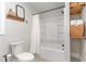 Bright bathroom featuring a shower-tub combo, open shelves with rolled towels and decorative wall art at 109 N Watauga Ave, Dunn, NC 28334