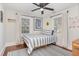 Comfortable bedroom with natural light, a striped bedspread, and an area rug over hardwood flooring at 109 N Watauga Ave, Dunn, NC 28334