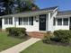 Charming single-story home featuring a classic black front door with a decorative wreath and a well-manicured lawn at 109 N Watauga Ave, Dunn, NC 28334